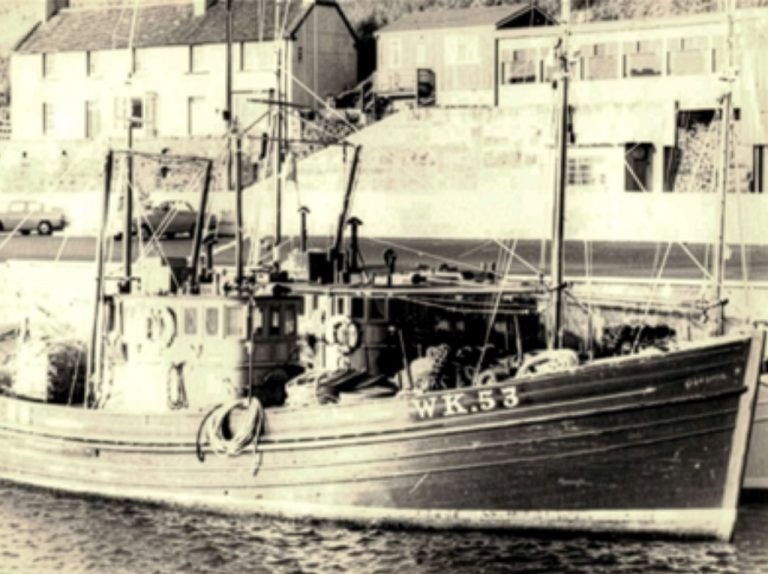 An old black and white picture of a fishing boat on Scrabster harbour. The vessel is numbered WK53